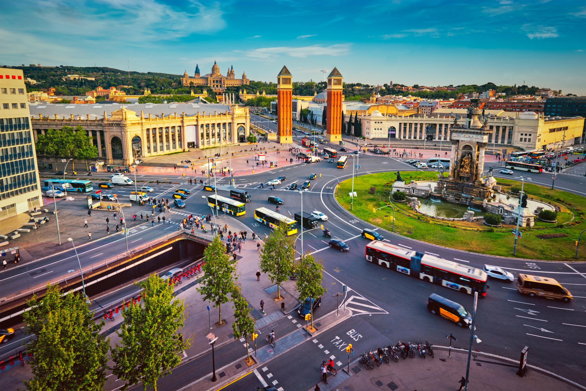 Plaza espanya barcelona Photo of Plaza espanya barcelona during the day. There is lots of traffic moving around the roundabout. You can see Montjuic in the background